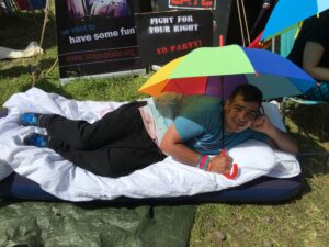 Jason lying on a blow up bed at Glastonbury whilst campaigning for his rights to a full social life.